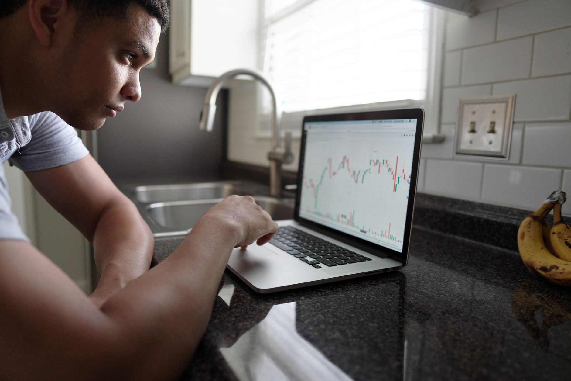 a person examining investment charts on a laptop with a worried expression