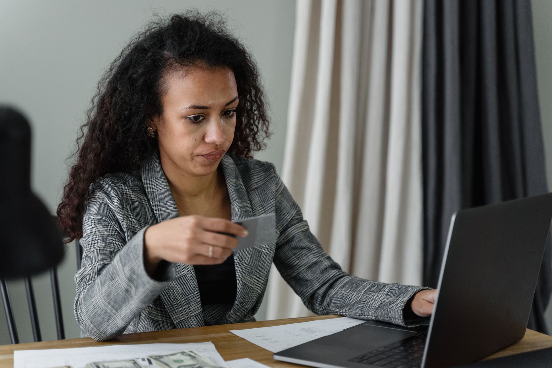 A shocked person looking at a credit card bill at a desk