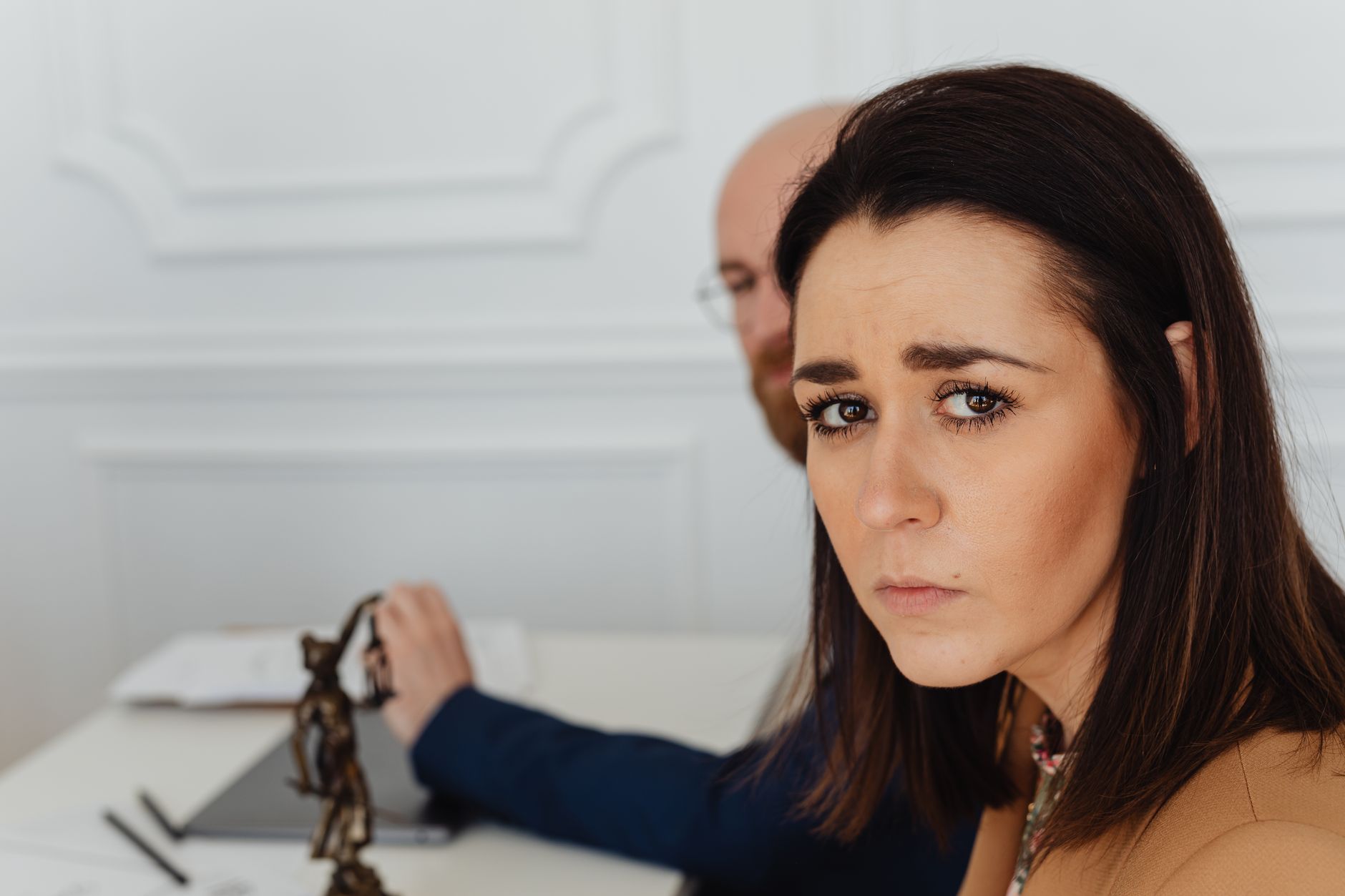 A creator at a desk reads a legal notice on a laptop with a concerned expression.